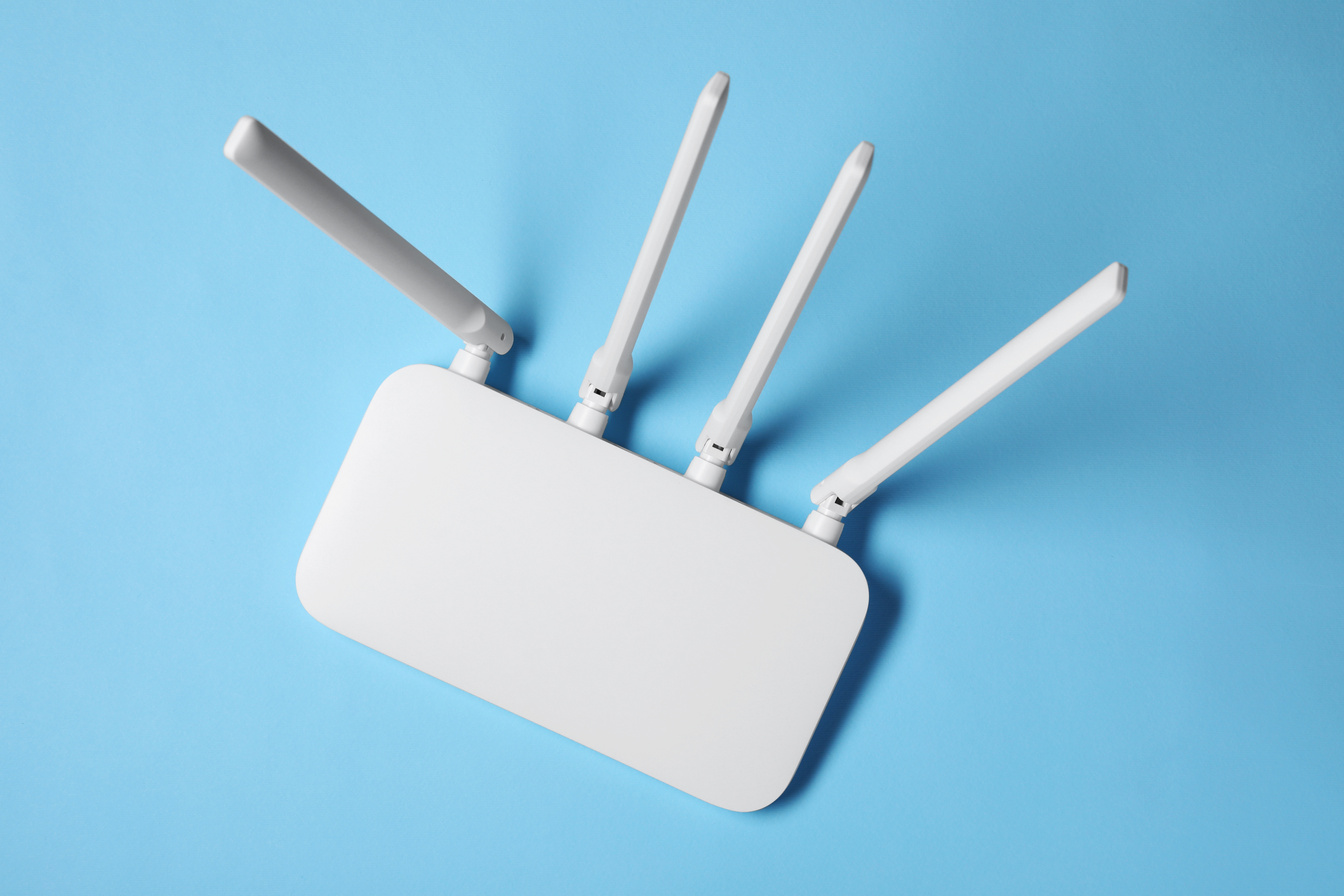 New White Wi-Fi Router on Light Blue Background, Top View