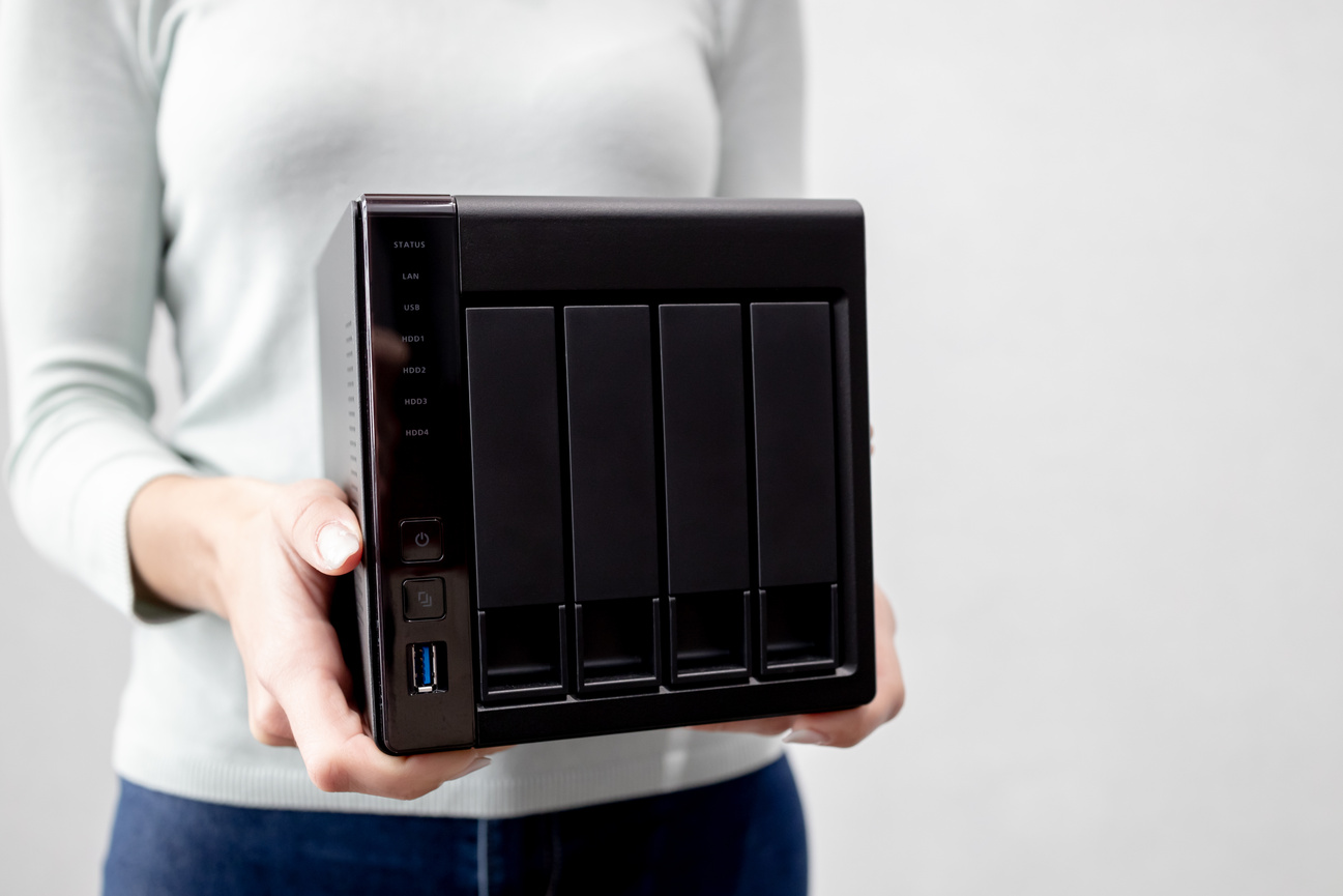 female holds small nas backup server. data backup and security concept.